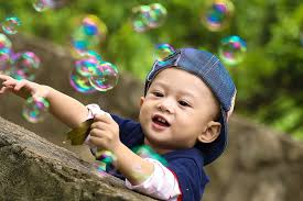 a young boy blowing bubbles
