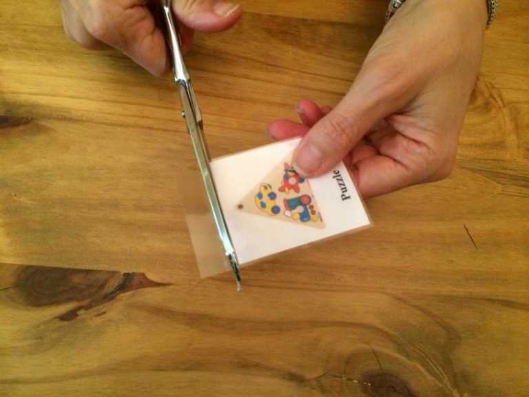 A woman cutting a picture with scissors.