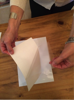 A woman covering a picture with contact paper.