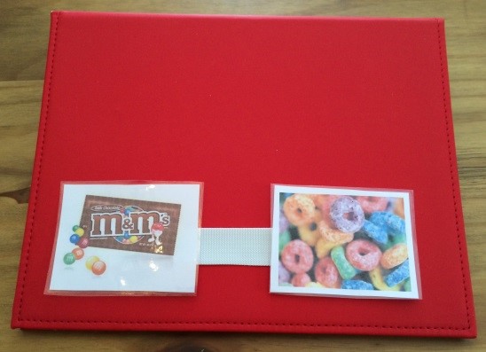 A PECS binder with pictures of m&ms and fruity cereal
