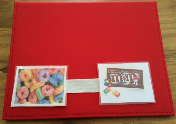 A PECS binder with images of fruity cereal and m&ms