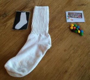 A sock and a pile of m&ms next to their pictures